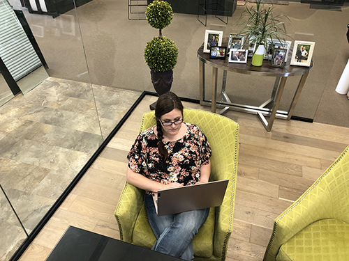 Overhead photo of women typing on computer in green chair